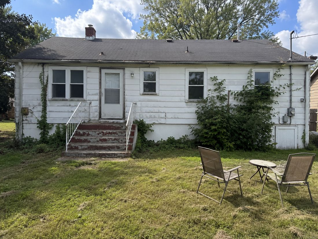 A white ranch home bought as-is, worn paint and all